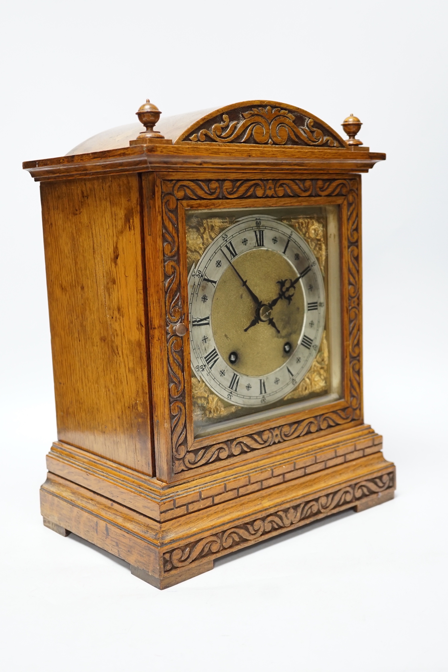An Edwardian carved oak mantel clock with engraved dial, 33cm high